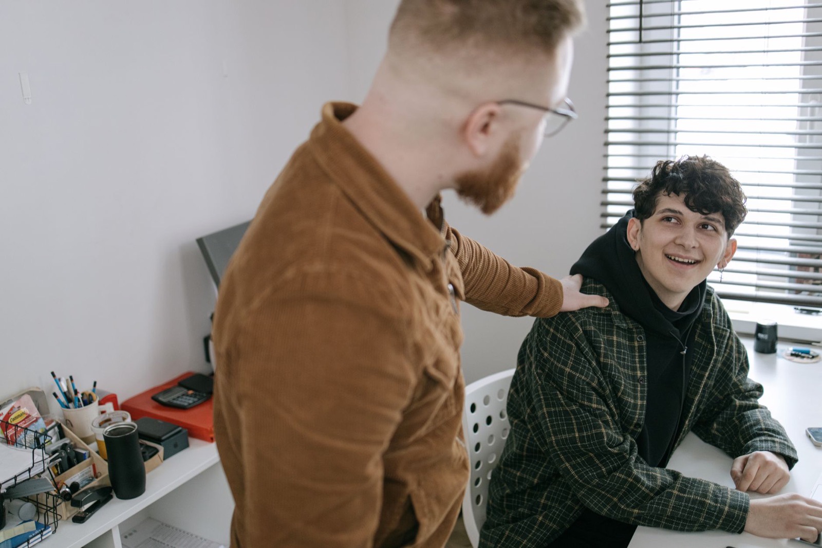 Persona joven formándose mientras trabaja junto a un compañero con experiencia